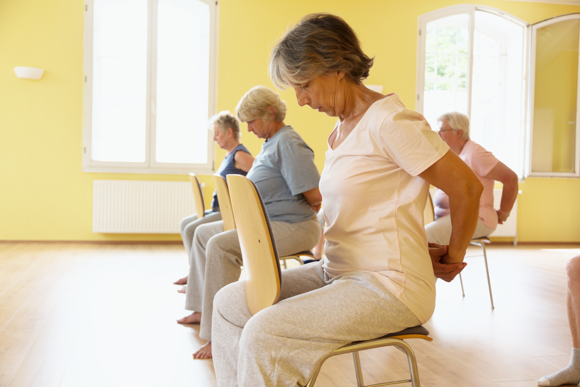 Yoga class: Senior women exercising on chair
